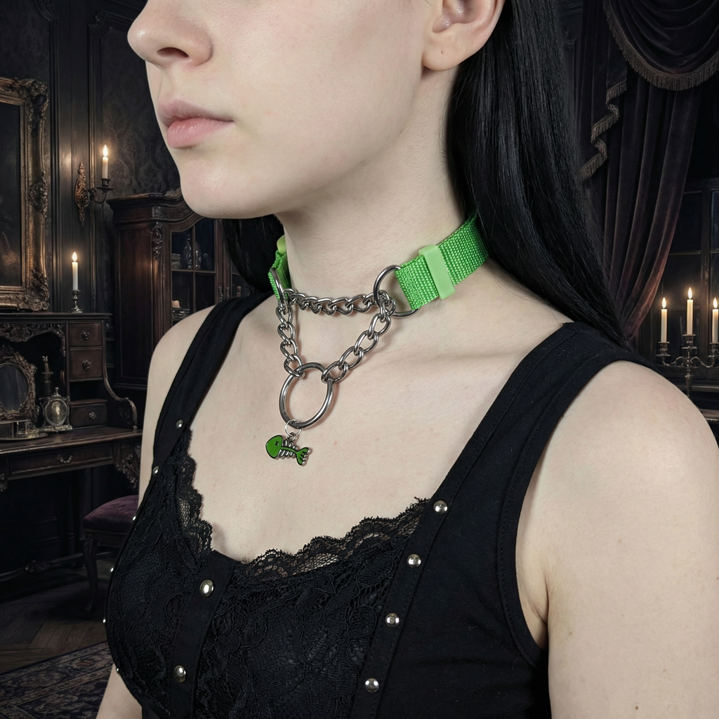 Person wearing a green choker necklace with a chain and small green charm in a dark, ornate room.