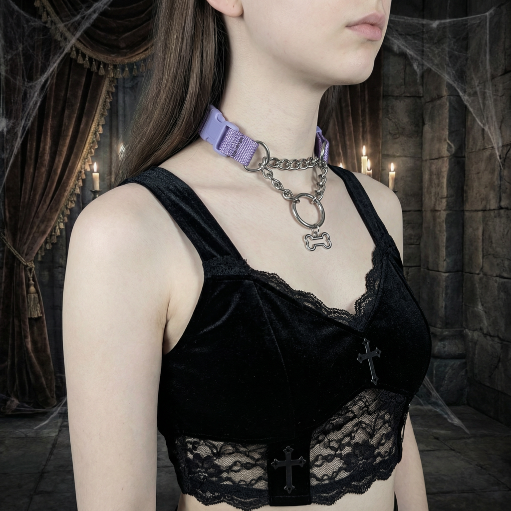 Person wearing a black lace top with a purple collar and chain in a dark, possibly gothic setting.
