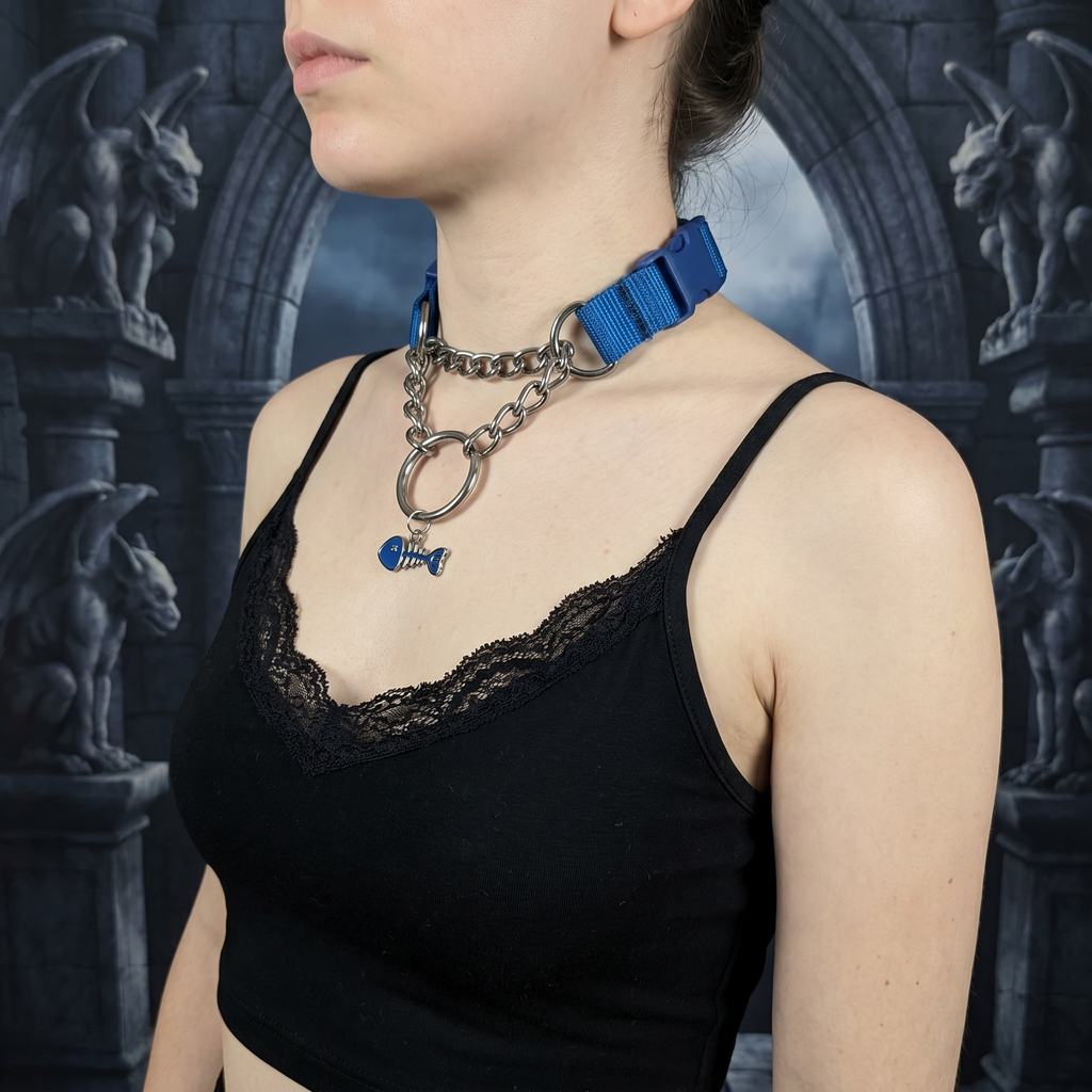Person wearing a black lace top with a blue ribbon and chain necklace against a dark, gothic-style background.