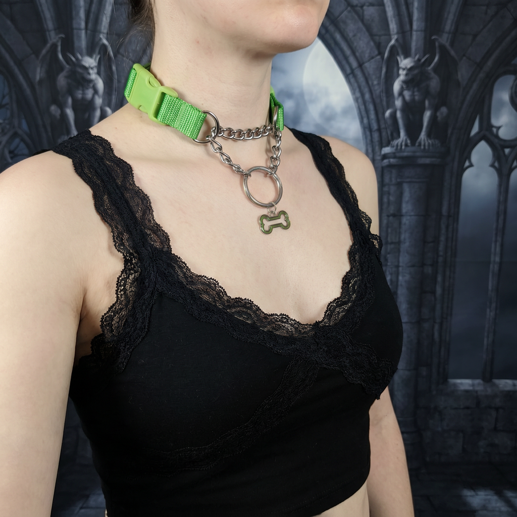 Person wearing black lace top and green choker with pull-chain and dog bone pendant.