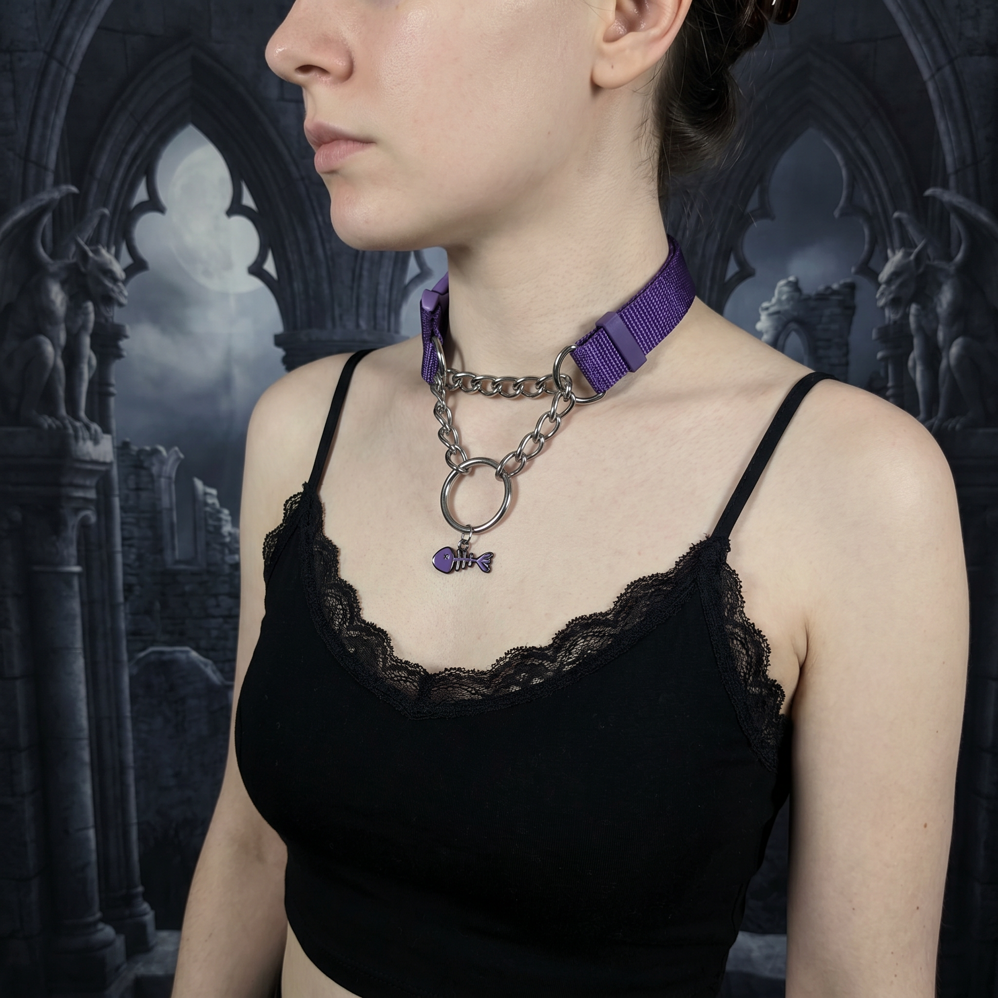 Person wearing a black lace top with a purple choker and chain necklace against a gothic-style background.