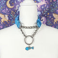Light blue and polished metal Pull-Chain choker necklace with matching fish bone pendant displayed on mannequin